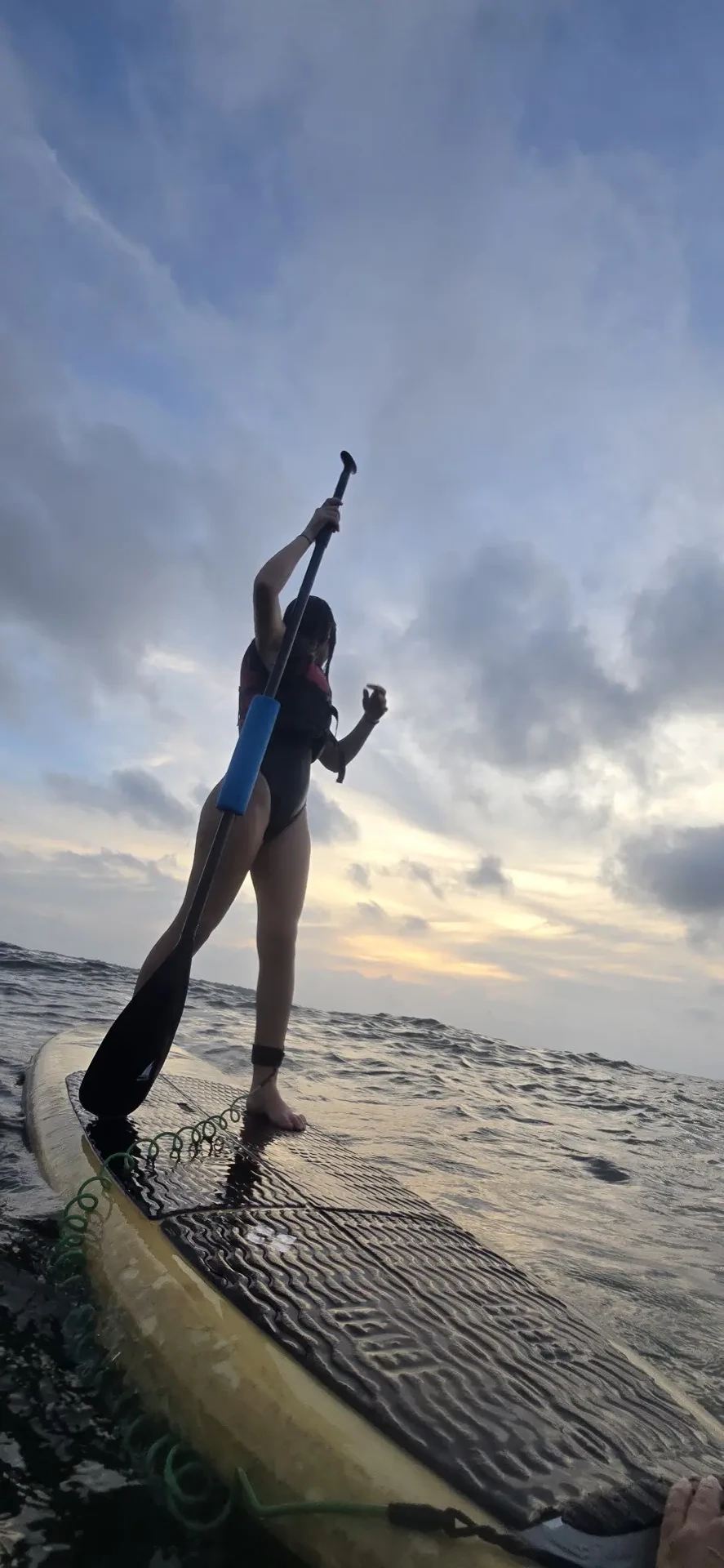 Silueta de paddleboard contra un cielo dramático al atardecer