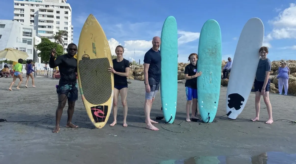 Familia con tablas de surf en la playa de Cartagena